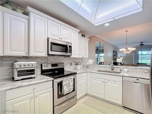 kitchen with stainless steel appliances, white cabinetry, and sink