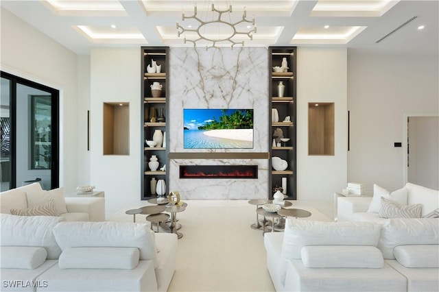 living area featuring built in shelves, coffered ceiling, beamed ceiling, and a high end fireplace