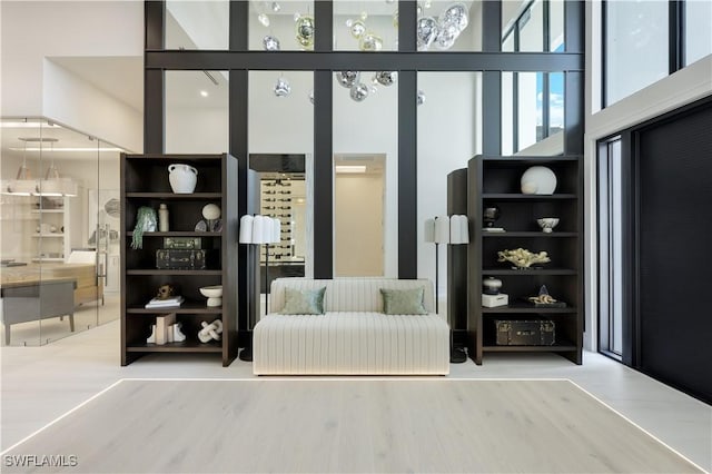 interior space featuring a towering ceiling and wood finished floors