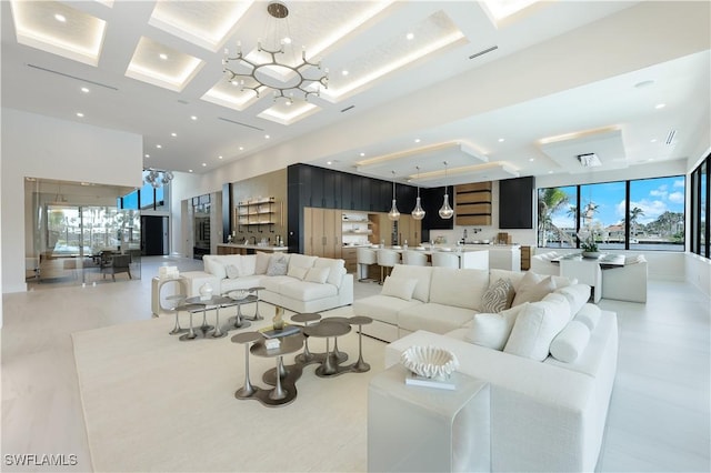 living room with visible vents, coffered ceiling, an inviting chandelier, a high ceiling, and recessed lighting