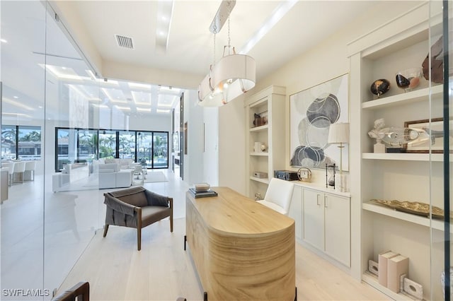 interior space featuring built in shelves, visible vents, and light wood-style flooring