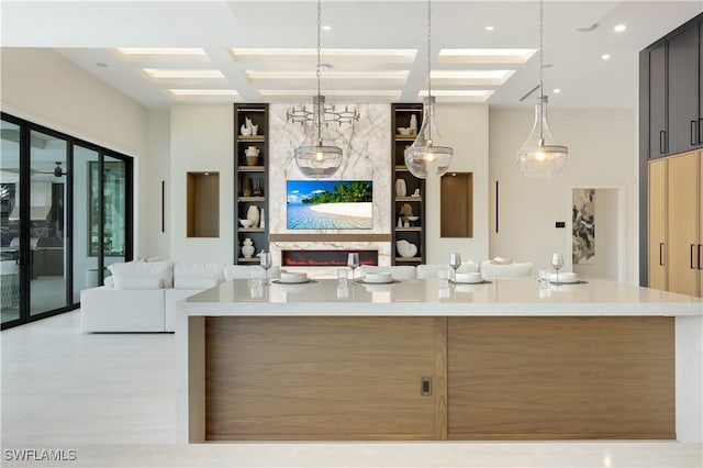 kitchen with coffered ceiling, open floor plan, light countertops, built in shelves, and beam ceiling