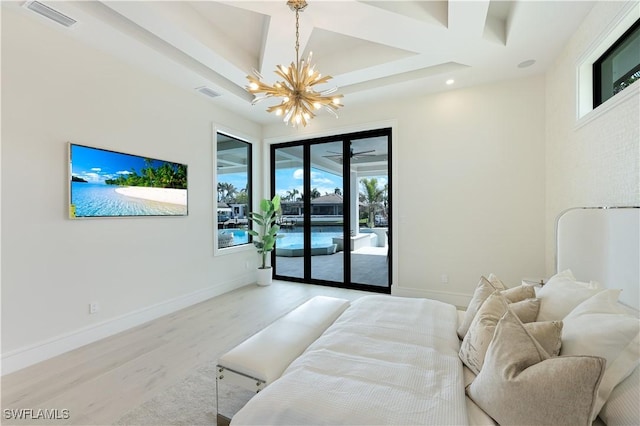 bedroom featuring a notable chandelier, wood finished floors, visible vents, baseboards, and access to exterior