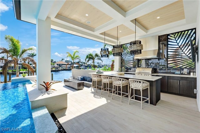 view of patio / terrace with outdoor lounge area, a water view, a grill, and outdoor wet bar