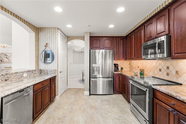 11600 Court Of Palms Unit 606, Fort Myers, FL 33908 - kitchen with stainless steel appliances, arched walkways, light stone countertops, backsplash, and recessed lighting