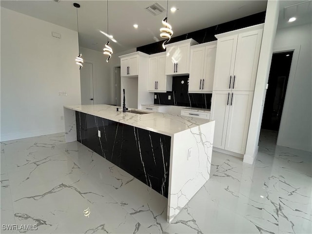 kitchen with marble finish floor, a large island, a sink, and visible vents