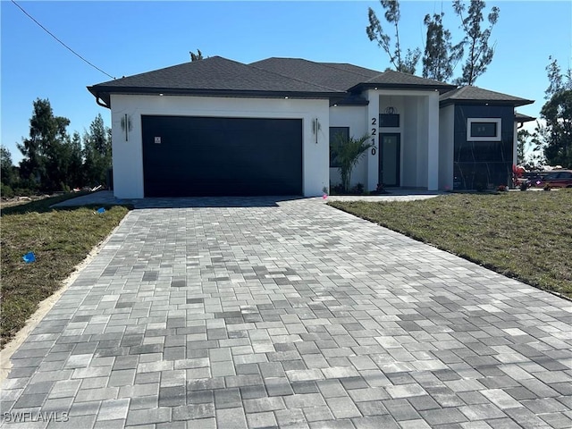 view of front facade with decorative driveway, an attached garage, and stucco siding