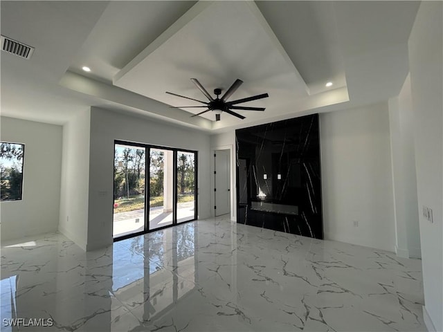 unfurnished living room featuring visible vents, a raised ceiling, ceiling fan, marble finish floor, and recessed lighting