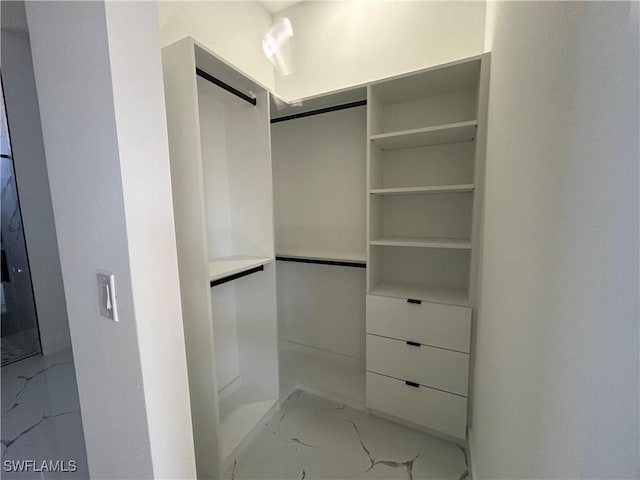 walk in closet with marble finish floor