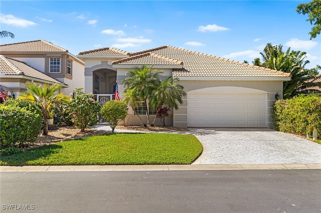 mediterranean / spanish home featuring a garage, a tile roof, driveway, and stucco siding