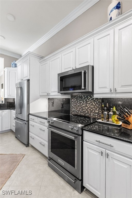 kitchen with appliances with stainless steel finishes, white cabinets, backsplash, and ornamental molding