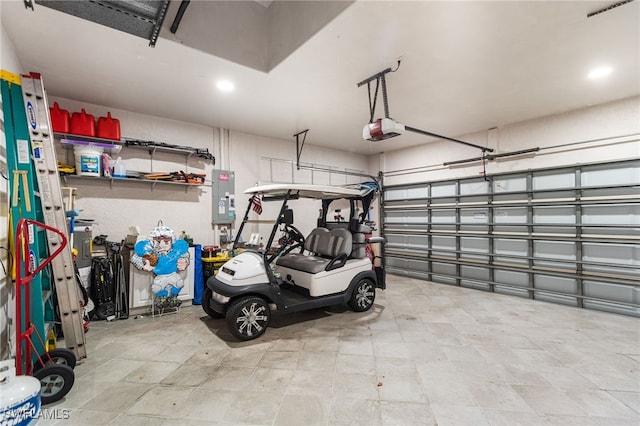 garage featuring recessed lighting, electric panel, and a garage door opener