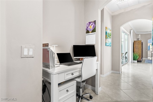 office area featuring arched walkways, light tile patterned floors, visible vents, baseboards, and ornamental molding