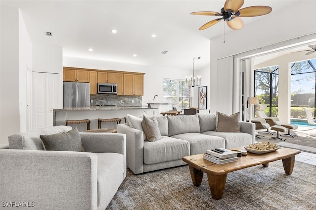 living area featuring recessed lighting, a healthy amount of sunlight, visible vents, and ceiling fan with notable chandelier