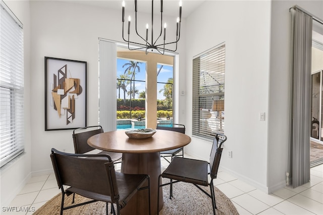 dining room featuring baseboards, an inviting chandelier, and light tile patterned floors