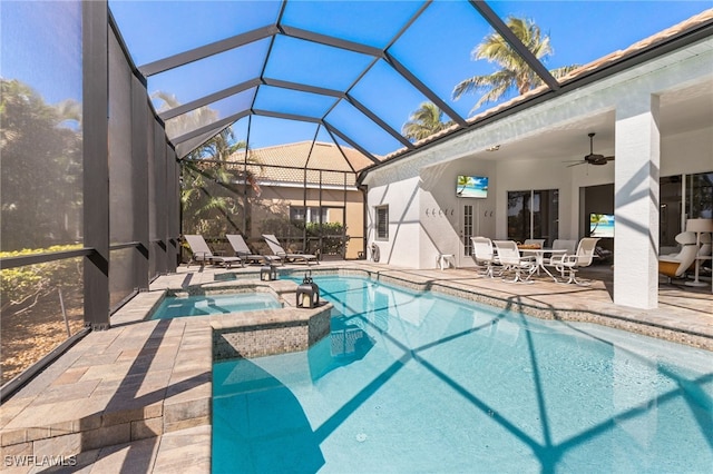 view of pool featuring glass enclosure, a patio, outdoor dining area, a pool with connected hot tub, and a ceiling fan