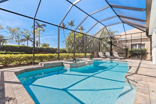 view of pool with a lanai, a pool with connected hot tub, and a patio