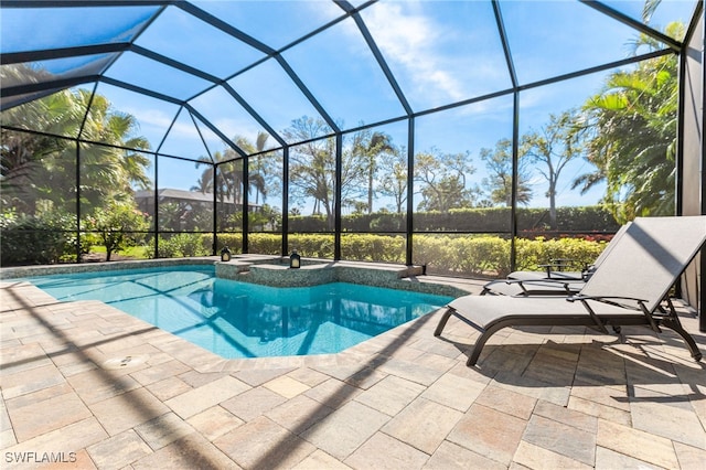 view of pool featuring a patio area, glass enclosure, and a pool with connected hot tub