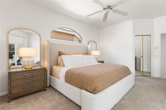 bedroom featuring a closet, light carpet, ceiling fan, and baseboards