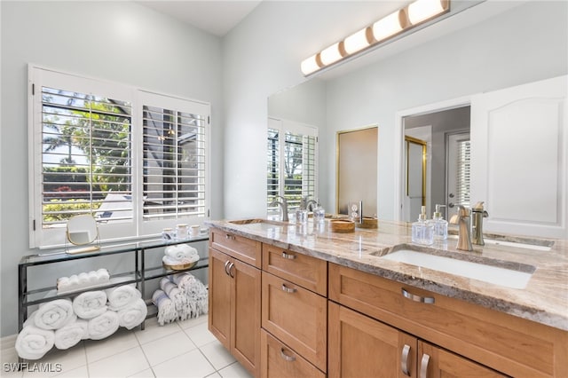 full bathroom with double vanity, tile patterned flooring, and a sink