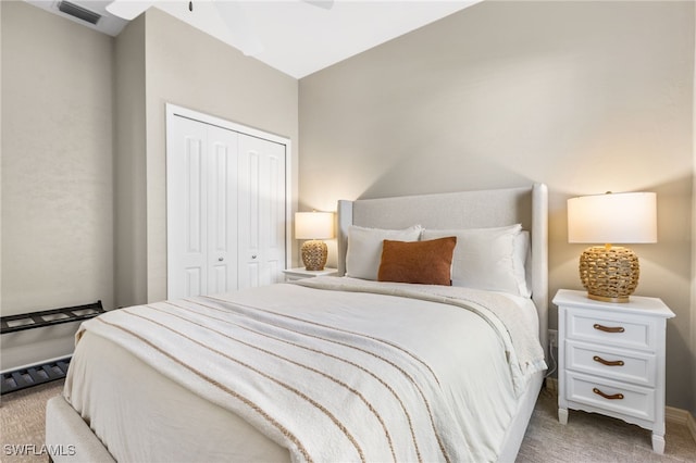 bedroom featuring light carpet, visible vents, and a closet