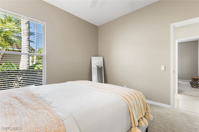 tiled bedroom with a ceiling fan, baseboards, and carpet flooring