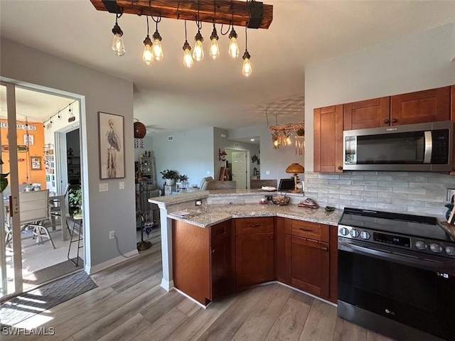 kitchen with stainless steel appliances, light hardwood / wood-style floors, decorative backsplash, decorative light fixtures, and kitchen peninsula