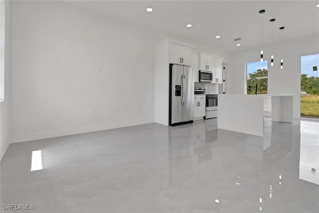 3310 14th St W, Lehigh Acres, FL 33971 - kitchen with stainless steel appliances, white cabinetry, a center island with sink, backsplash, and pendant lighting