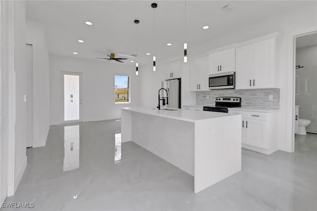 3310 14th St W, Lehigh Acres, FL 33971 - kitchen featuring stainless steel appliances, white cabinets, tasteful backsplash, an island with sink, and recessed lighting