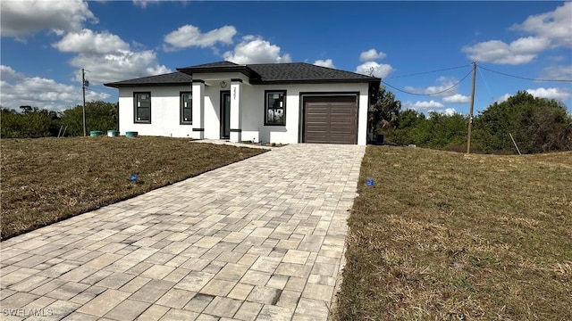 view of front of home featuring a garage and a front yard