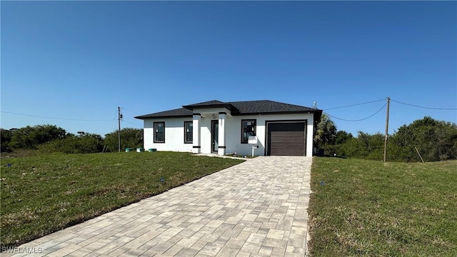 view of front of house featuring stucco siding, an attached garage, decorative driveway, and a front yard