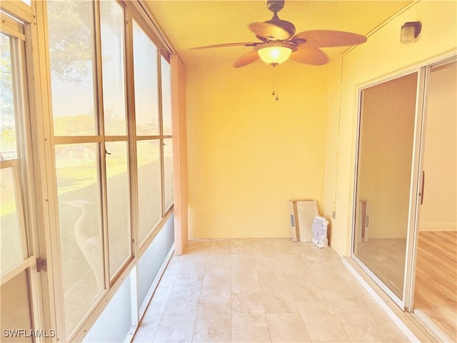 unfurnished sunroom featuring ceiling fan