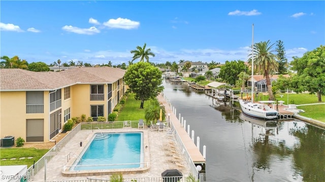 view of pool featuring cooling unit, a dock, a patio, and a water view