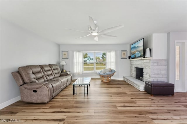 2084 Coral Point Dr, Cape Coral, FL 33990 - living room featuring light wood-style floors, baseboards, a ceiling fan, and a stone fireplace