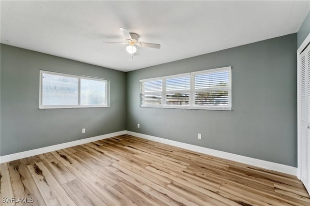 2084 Coral Point Dr, Cape Coral, FL 33990 - empty room with a healthy amount of sunlight, baseboards, wood finished floors, and ceiling fan