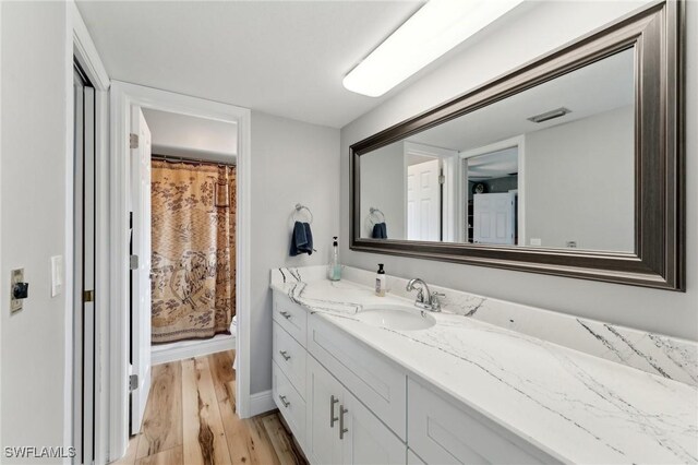 2084 Coral Point Dr, Cape Coral, FL 33990 - full bathroom featuring vanity, baseboards, toilet, visible vents, and wood finished floors