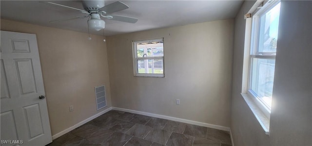 unfurnished room featuring a ceiling fan, visible vents, and baseboards