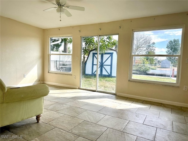 entryway with ceiling fan and baseboards