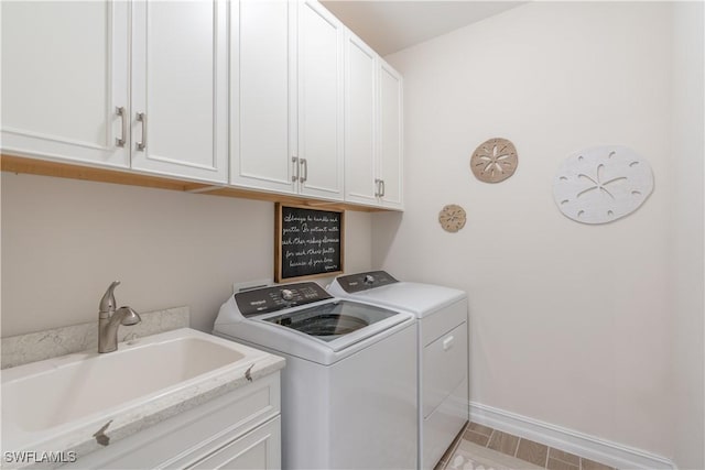 laundry area with washer and dryer, cabinets, and sink