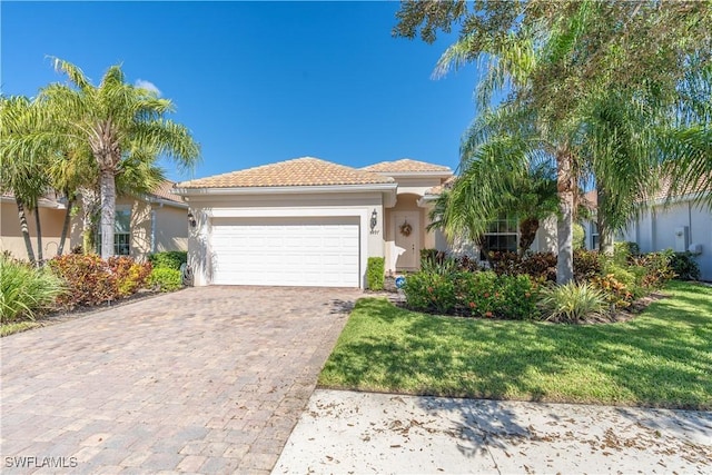 mediterranean / spanish home featuring a front lawn and a garage