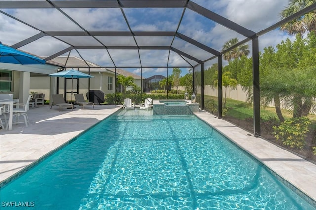 view of swimming pool with a pool with connected hot tub, a grill, and a patio