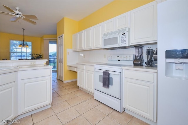 kitchen featuring white appliances, white cabinetry, and hanging light fixtures