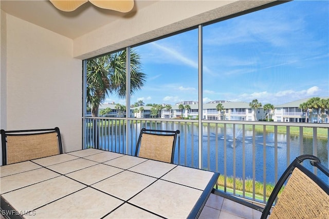 unfurnished sunroom with a water view and ceiling fan