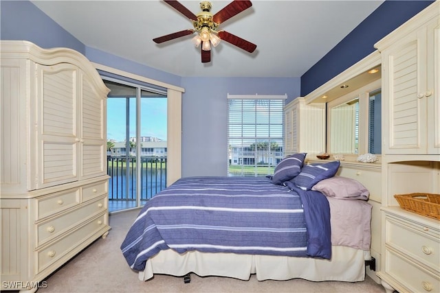 carpeted bedroom featuring ceiling fan, a water view, and access to outside