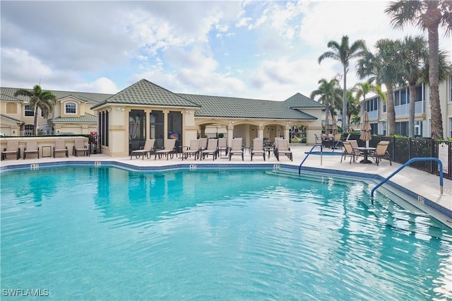 view of swimming pool featuring a patio area and exterior bar