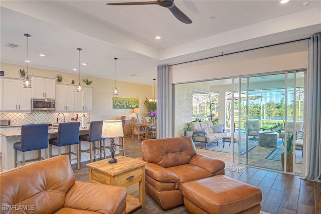 living area with dark wood-style floors, recessed lighting, visible vents, and a ceiling fan