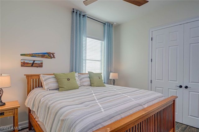 bedroom with ceiling fan, a closet, and dark wood-style floors