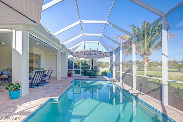 outdoor pool with glass enclosure and a patio