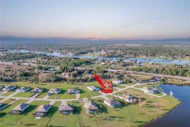 aerial view at dusk featuring a water view