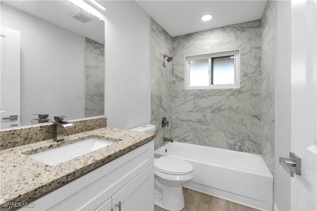 full bathroom with toilet, vanity, tiled shower / bath, and wood-type flooring